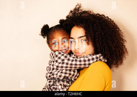 Close portrait of woman with little black girl hugging holding on hands and smile Stock Photo