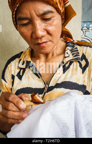 Portrait of a woman working on making a design on a handmade tablecloth Stock Photo