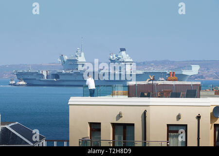 The Royal Navy Aircraft Carrier, HMS QUEEN ELIZABETH, Being Moved From Her Berth By 5 Tugs Prior To Her Departure From Portsmouth To Rosyth, Scotland. Stock Photo