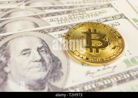 Bitcoin coin and banknotes of one hundred dollar. Conceptual image for global cryptocurrency blockchain payment system. Stock Photo