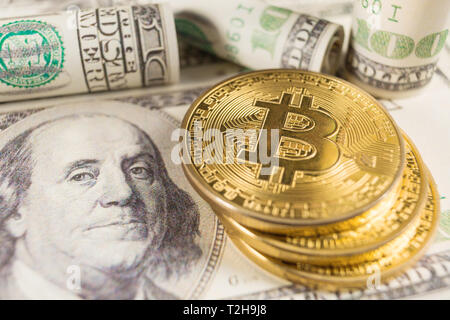 Bitcoin stack and banknotes of one hundred dollar. Conceptual image for global cryptocurrency blockchain payment system. Stock Photo
