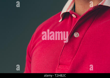 Close up of a young adult caucasian male wearing a red polo shirt Stock Photo