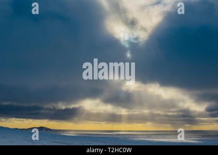 Sunlight shines shining through dark clouds on the sea, in winter, peninsula Snaefellsnes, Iceland