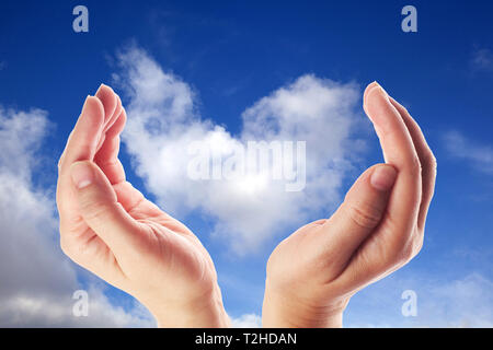 Hand holding the cloud for concept world wide data sharing and communication. Blue sky Stock Photo