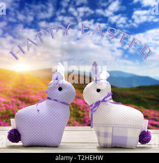 Two Easter yellow bunnies with happy easter text. Easter holiday concept. Stock Photo