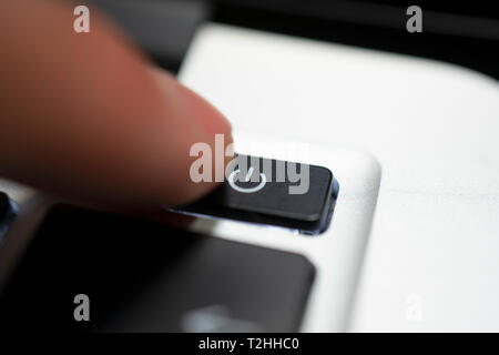 human hand press shutdown button on computer keyboard Stock Photo