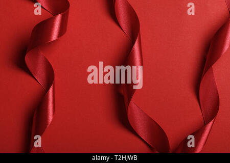 close up of curved satin red ribbons on red background Stock Photo by  LightFieldStudios