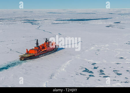 Aerial of the Icebreaker '50 years of victory' on its way to the North Pole breaking through the ice, Arctic Stock Photo