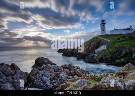 Sunrise over the Atlantic Ocean and Fanad Head Lighthouse in County Donegal, Ulster, Republic of Ireland, Europe Stock Photo