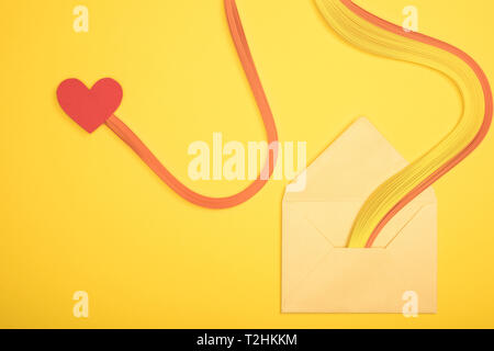 top view of open envelope with rainbow and heart sign on yellow background Stock Photo