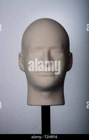 front portrait white mannequin head on stick with gray background Stock Photo