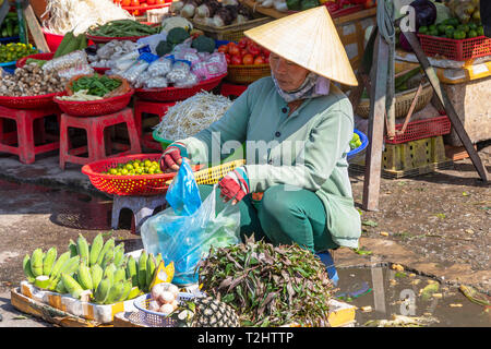 Woman selling bananas, pineapples, eggs and herbs from a street stall at the outdoors market, Dinh Cau, Phu Quoc Island, Vietnam, Asia, Stock Photo