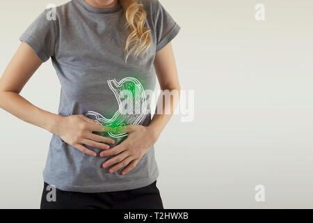 Digital composite of highlighted green  stomach of woman with infection Stock Photo