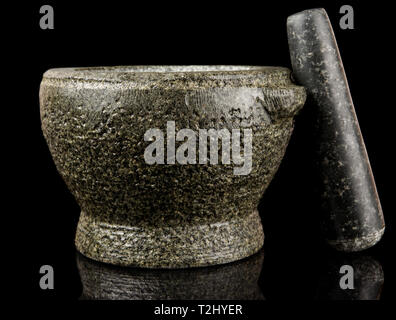 Granite mortar used for making sauces isolated on black background Stock Photo