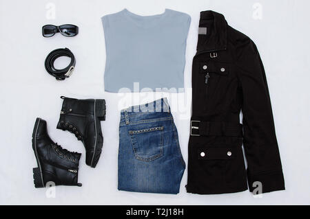 Layout clothes. Black jacket, boots, belt, glasses, jeans and a gray T-shirt. View from above. White background. Stock Photo