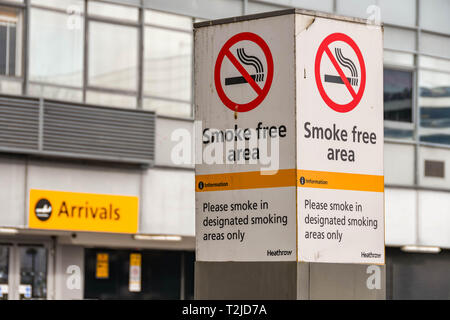 LONDON HEATHROW AIRPORT, ENGLAND - FEBRUARY 2019:  Sign outside Terminal 3 at London Heathrow Airport warning visitors the area is smoke free. Stock Photo