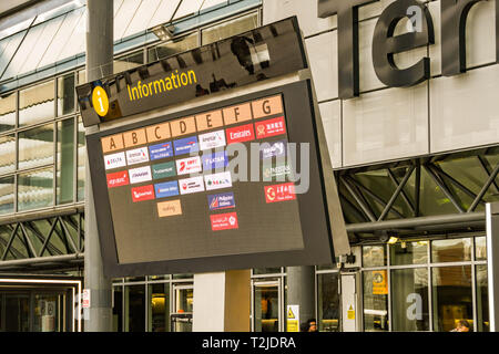 LONDON HEATHROW AIRPORT, ENGLAND - FEBRUARY 2019:  Airline logos showing on an electronic display screen outside London Heathrow Airport Terminal 3 Stock Photo