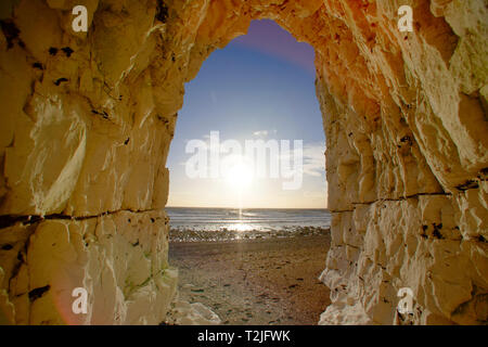 View of a sunset from a cave in the chalk cliffs near Beachy Head, Eastbourne, East Sussex, UK