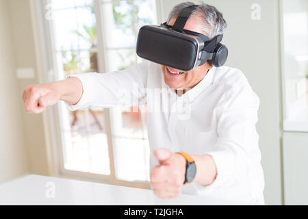 Man wearing virtual reality glasses smiling looking very happy and excited Stock Photo