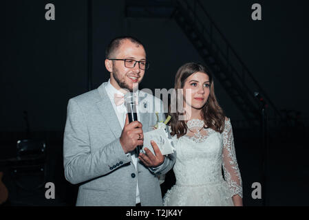 The bride and groom at the microphone party thank guests and parents. Stock Photo