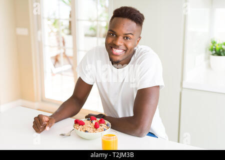 Handsome african american man eating heatlhy cereals and berries as breakfast Stock Photo