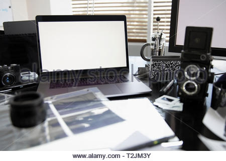 Laptop and photography equipment on desk