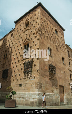 People in front of the Casa de las Conchas with facade adorned by shells at Salamanca. The city preserves many buildings of ancient Rome in Spain. Stock Photo