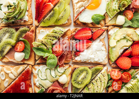 background of delicious toasts with fruits and vegetables isolated on white Stock Photo