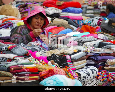 PURMAMARCA, AR - CIRCA OCT, 2018 - Andean woman sells colorful tissues of alpaca wool in the market of Purmamarca. Stock Photo