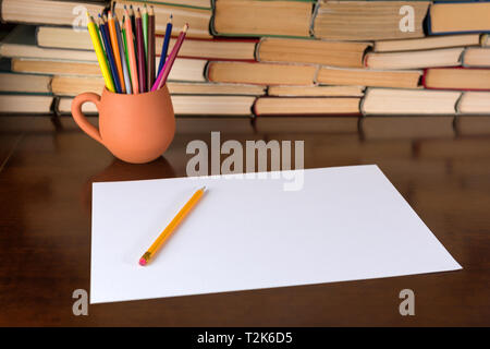 Paper and pencils on the wooden table, books background Stock Photo