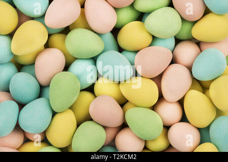 Top view on mini chocolate easter eggs candies as a background. Copy space for your text. Stock Photo
