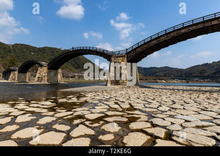 Kintai Bridge stands gracefully over the Nishiki River, and is a national treasure.  It was originally constructed in 1673. The wooden bridge with its Stock Photo