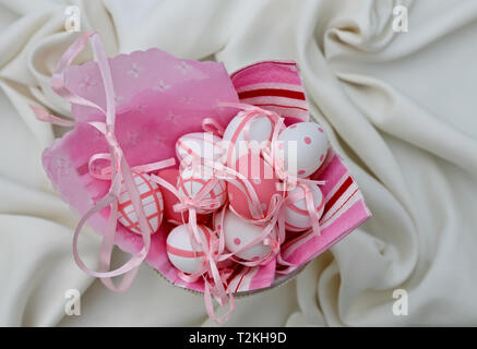 Small pink and white easter eggs on a white textile background Stock Photo