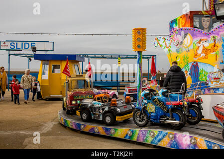 The funfair and small theme park on the promenade in the coastal town of Hunstanton Norfolk on a dull and overcast day in the middle of March. The rid Stock Photo