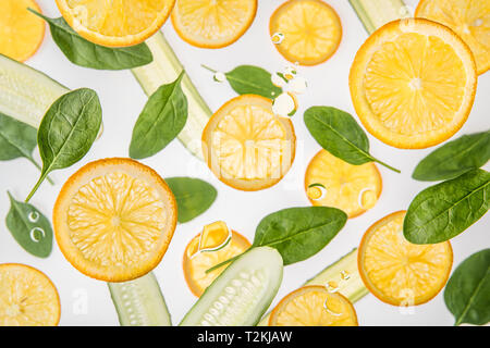 fresh orange slices with green spinach leaves and cucumbers on grey background Stock Photo