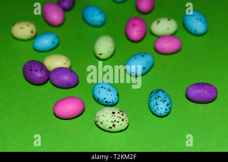 Scattered Speckled Candy Eggs On Green Surface Stock Photo
