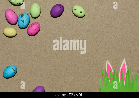 Speckled Eggs With Grass Patch And Rabbit Ears On Natural Cardboard Stock Photo