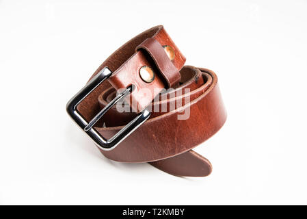A product shot of a men's brown belt with patina set on a plain white background. Stock Photo