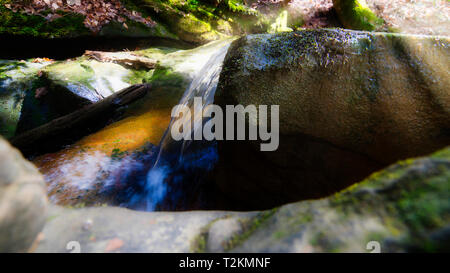 The water cascades over the boulders at the Natural Bridge in northern Alabama. Stock Photo