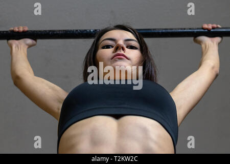 The girl is engaged on the bar in the gym Stock Photo