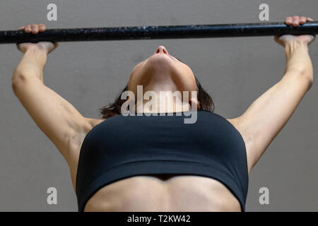 The girl is engaged on the bar in the gym Stock Photo