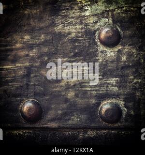 Closeup of grunge black metal plate with rivets and screws as background or texture. Square format. Stock Photo