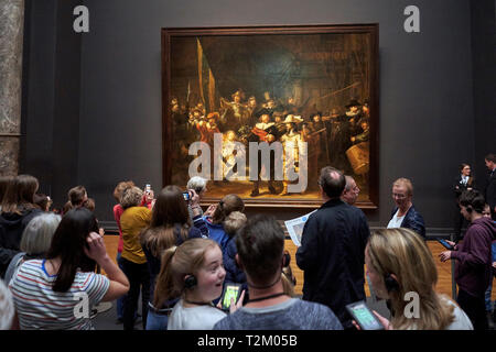 Visitors to the Rijksmuseum observe the painting 'Night Watch' by Rembrandt. 2019 marks the 350th anniversary of Rembrandt's death. Stock Photo