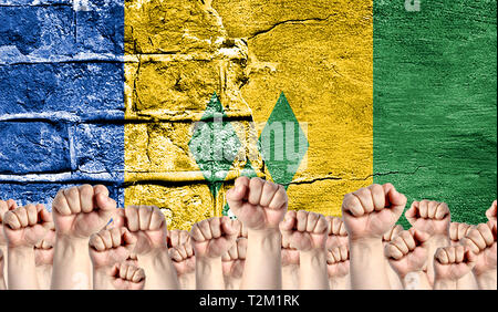 Male hands clenched in a fist raised up against the backdrop of a destroyed brick wall with a flag of Saint Vincent and the Grenadines. The concept of Stock Photo