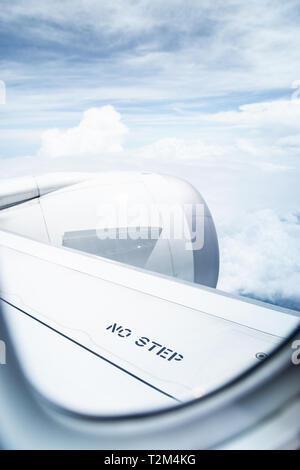 No step sign on commercial airplane wing, airplane in flight, shot through the window. Stock Photo