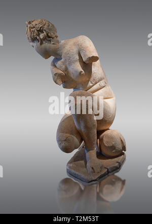 Crouching Aphrodite (Venus). 2nd Century  Roman Marble Statue from Marmol. Cordoba Archaeological Museum, Spain.  Grey Background Stock Photo