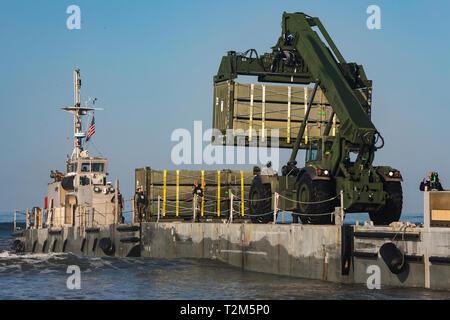 U.S. Marines with 1st Transportation Support Battalion, 1st Marine Logistics Group, and Sailors with Beach Master Unit 1, Naval Beach Group 1, offload supplies during Pacific Blitz 19 at Marine Corps Base Camp Pendleton, California, March 25, 2019. The Arrival and Assembly Operations Group’s function is to coordinate and control arrival and assembly operations. It consists of personnel from all Marine Air-Ground Task Force elements plus liaison from the commander, Navy support element, expeditionary medical facilities, and naval mobile construction battalions. (U.S. Marine Corps photo by Lance Stock Photo