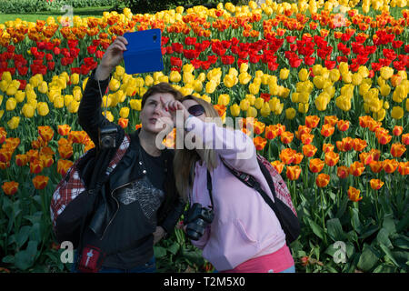 Two women make a selfie in front of the tulips of Keukenhof Park Stock Photo
