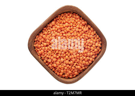 Raw uncooked red lentils (lens culinaris) in wooden bowl isolated on white background Stock Photo