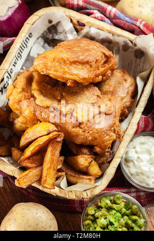 Traditional fish in beer batter and chips served on basket. Top view Stock Photo